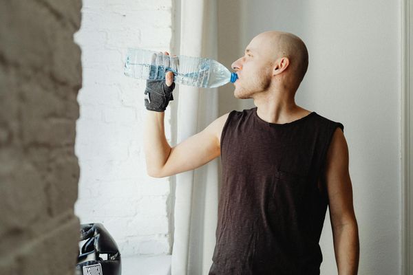 Man performing a controlled bodyweight exercise in a minimalist gym setting.