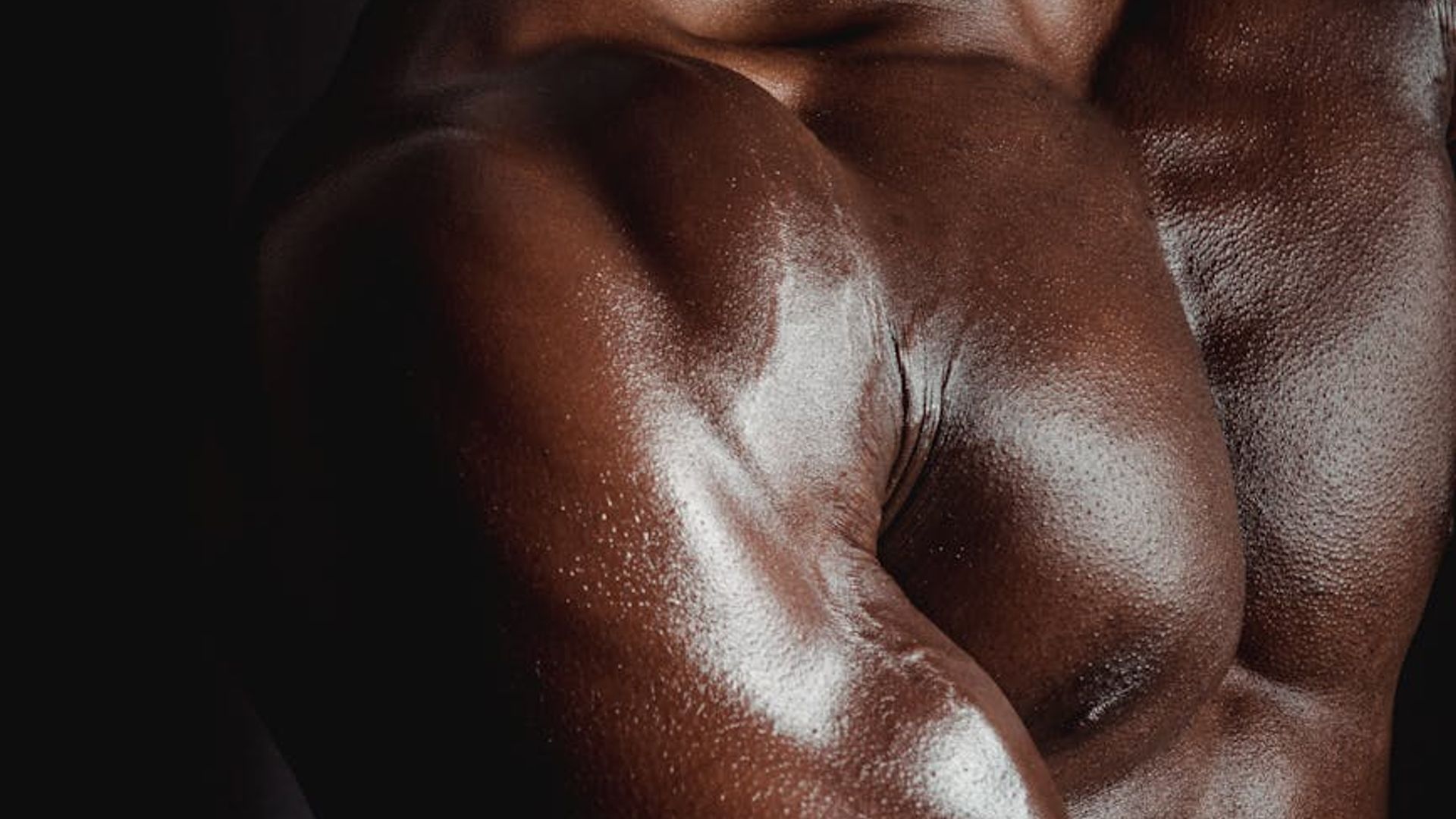 Silhouette of a man in a powerful stance against a dark background.